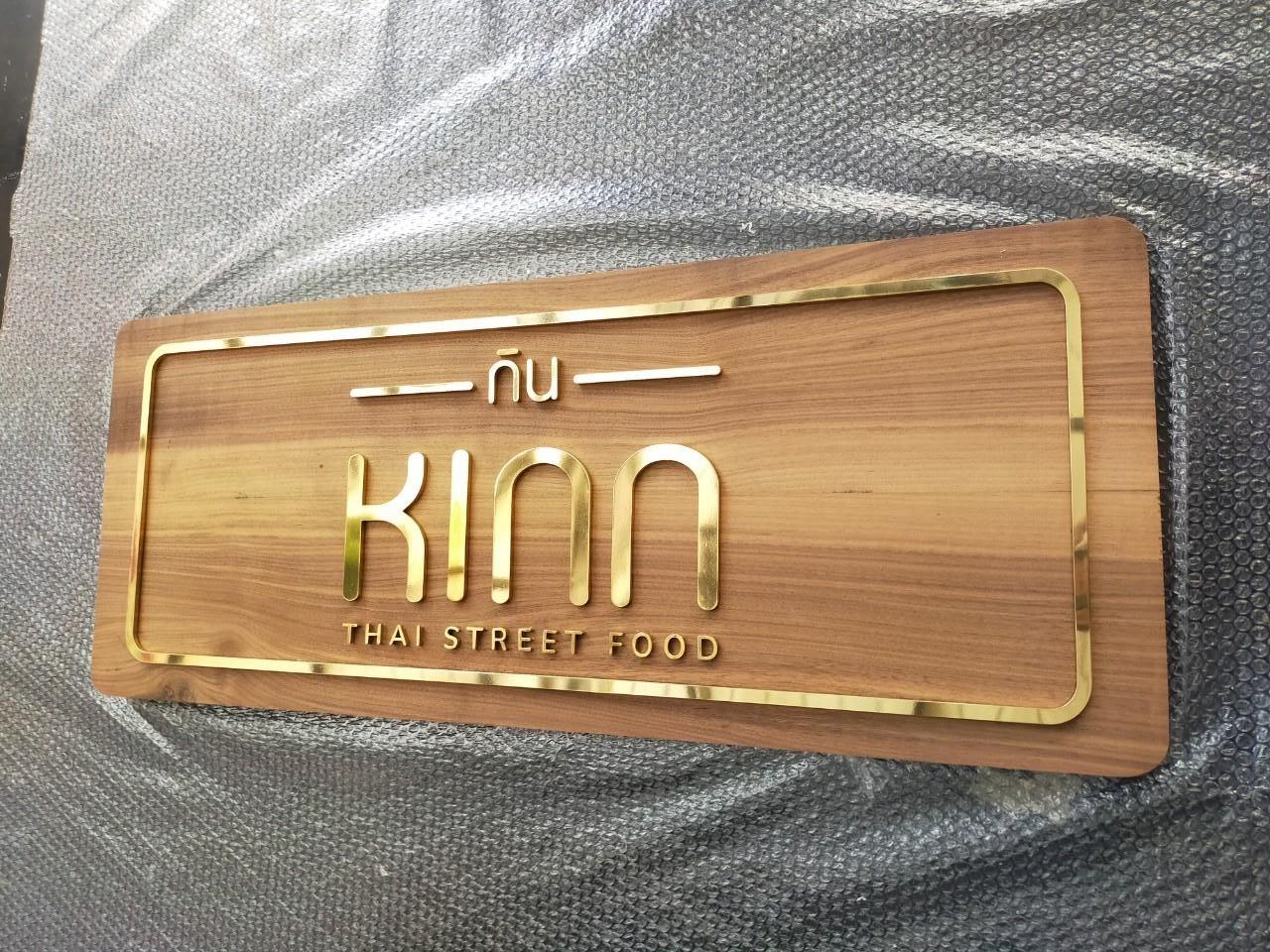 ป้ายอักษรทองเหลืองขัดเงา ยกขอบ รองพื้นไม้